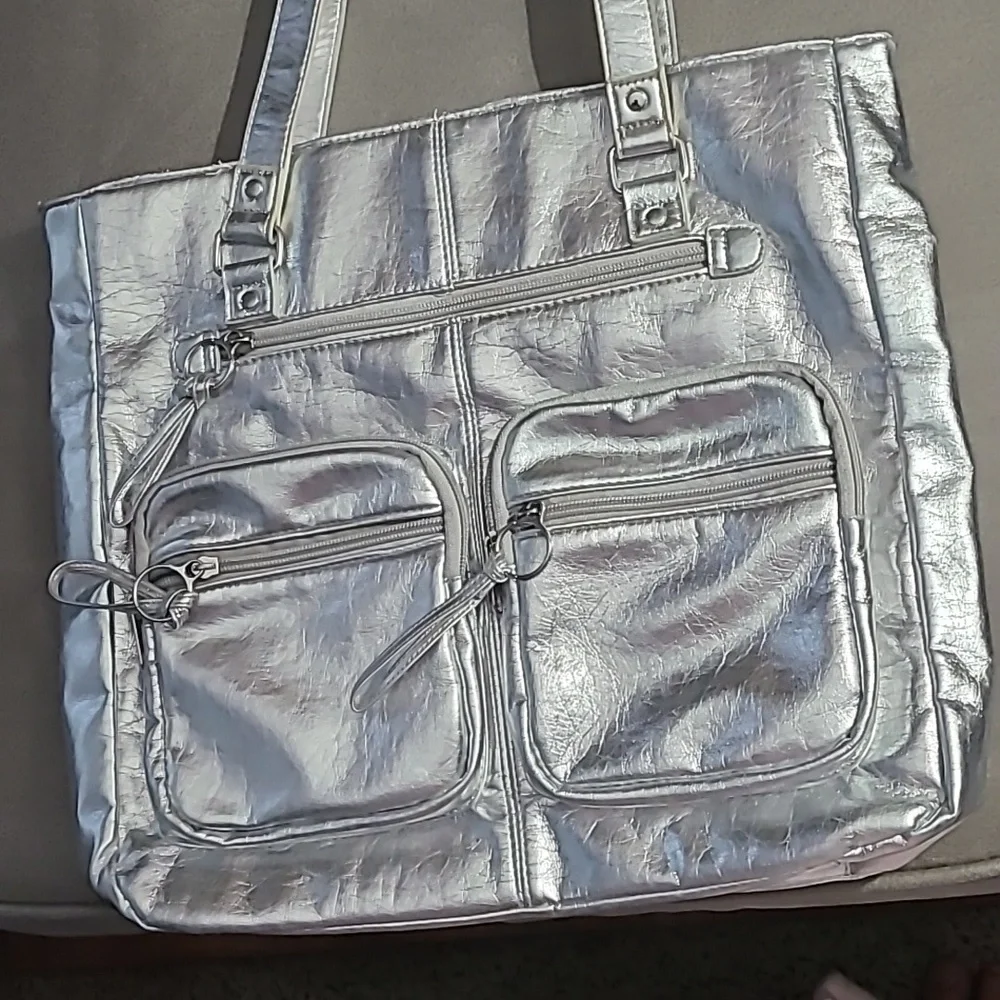 Shiny silver metallic handbag. Outside pockets snap closure‎ clean inside